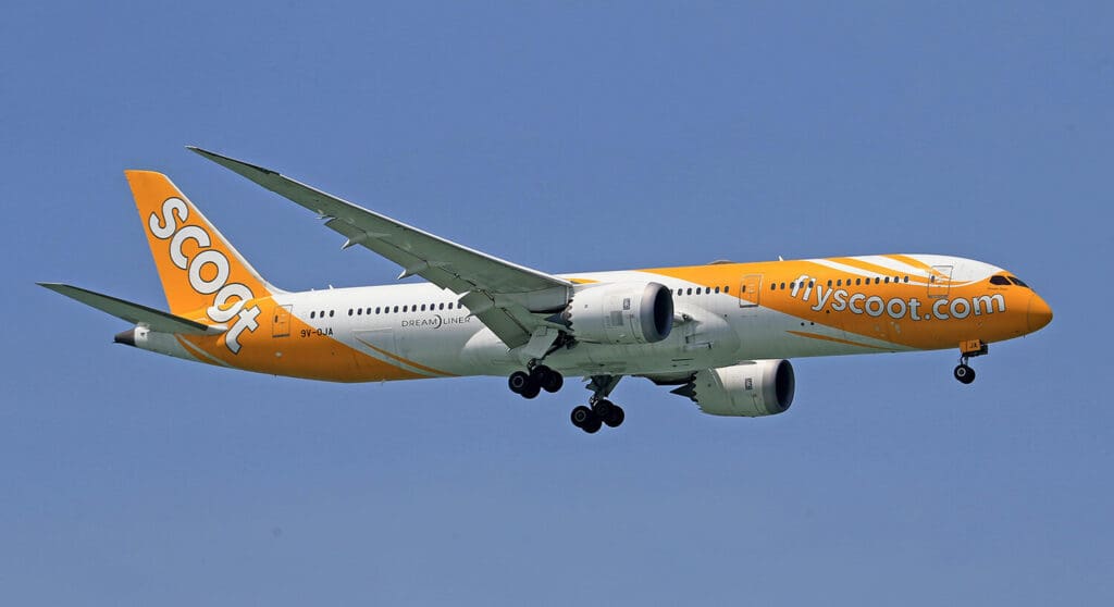 Scoot Airlines dreamliner aircraft with it's yellow and white livery. Wheels down preparing to land. Learn about Scoots surfboard fees and policy