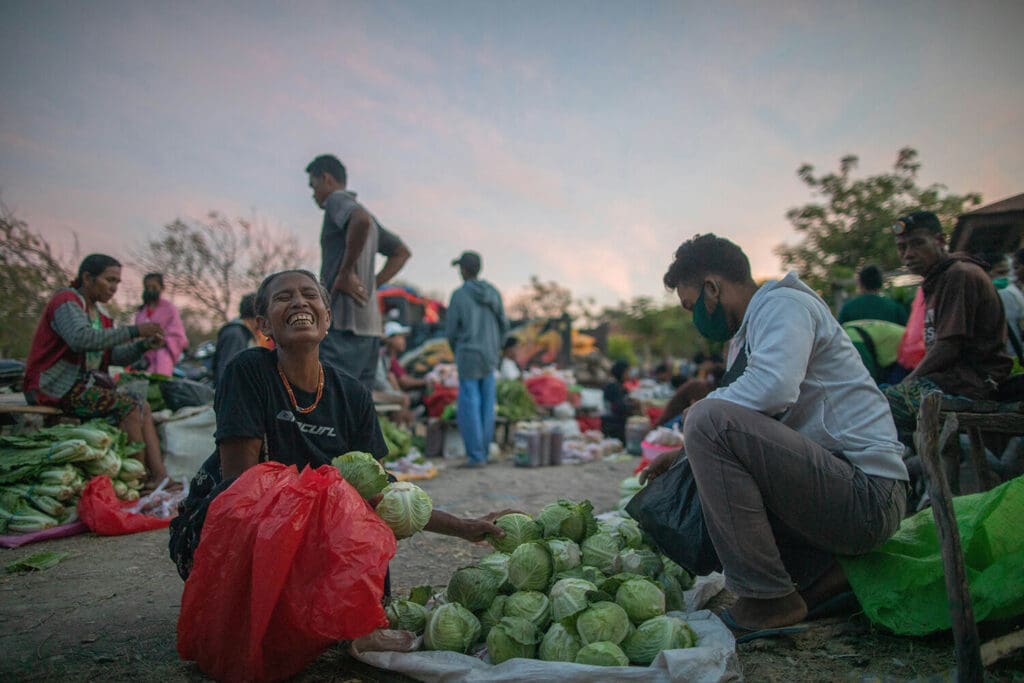 A local lady from Sabu Raijua Islands smiles for the camera as she collects vegetables at the local market. 